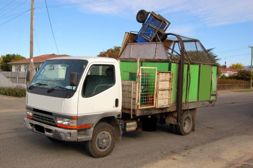 Workers arranging a skip and securing site safety signs